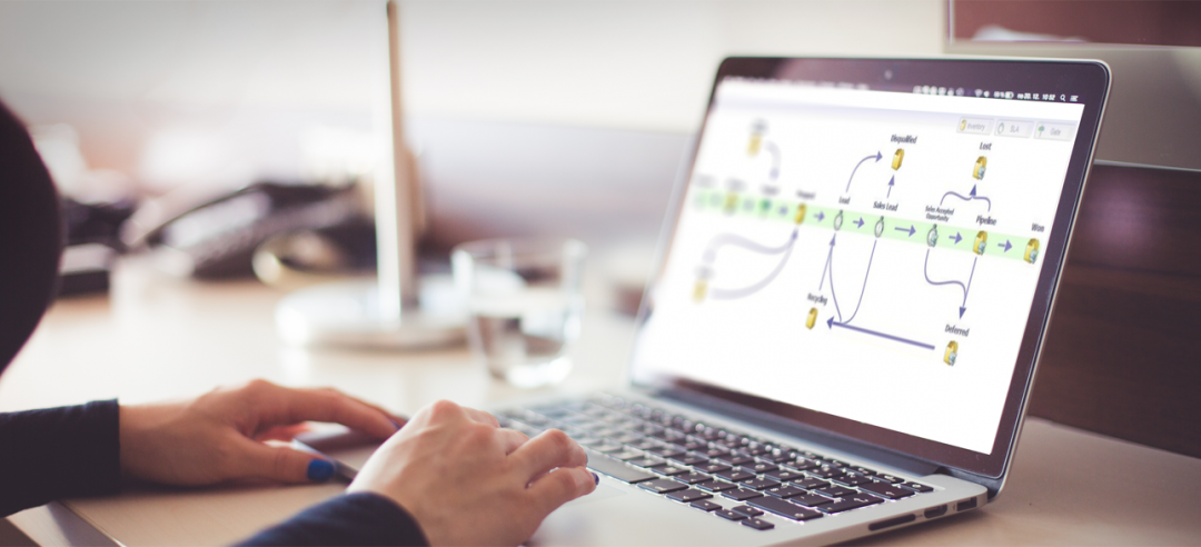 Open laptop showing a Marketo revenue cycle model of a customer journey