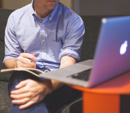Man sitting at desk looking at laptop